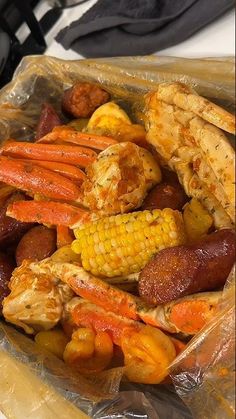 a plastic bag filled with assorted meats and veggies on top of a table