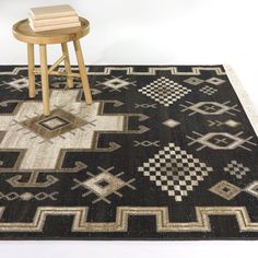 a black and white area rug with a wooden stool