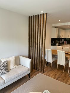 a living room filled with furniture next to a dining room table and kitchen counter top