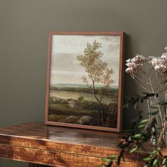 a painting on a table next to a vase with flowers