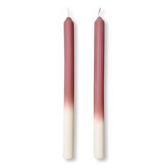 two candles with pink and white ombreaches on them, one is red