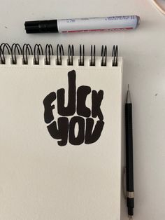 a notepad with the word fluck you written on it next to a pen