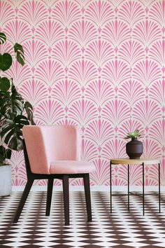 a pink chair sitting next to a table on top of a checkered floor