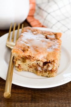 a piece of cake sitting on top of a white plate next to a gold fork