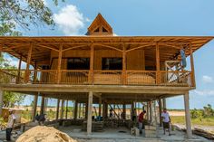 people are standing in front of a wooden structure with balconies on the roof