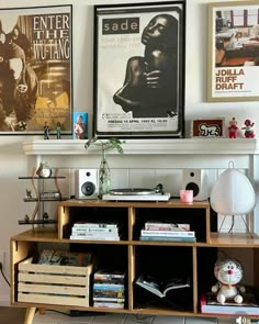 there is a shelf with many books on it and pictures above the bookcases