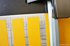 the ruler is on top of some yellow paper next to a black and white object