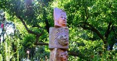 three heads are stacked on top of each other in front of some trees and bushes