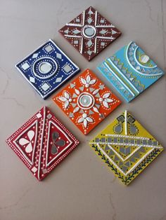 four different colored tiles with designs on them