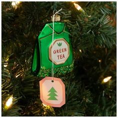 a green tea bag ornament hanging from a christmas tree