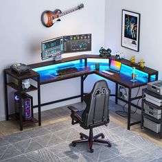 a computer desk with two monitors and keyboard on it in front of a guitar wall