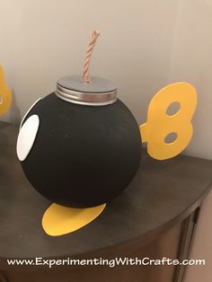 a black vase with yellow and white decorations on it