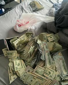 a pile of money sitting on top of a bed