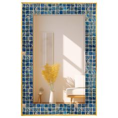 a vase with yellow flowers sitting in front of a blue and white tile wall mirror