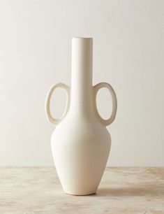 a white vase sitting on top of a table