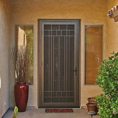 the front door to a home with potted plants