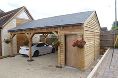 a car is parked in front of a wooden garage with flowers on the windows and doors