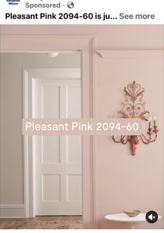 a pink room with a chandelier hanging on the wall and a white door