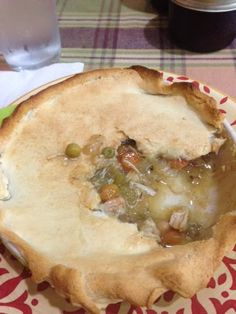 a plate with a pie on it and a glass of water in the back ground