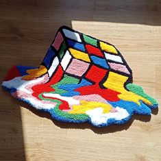 a multicolored rug on the floor that is shaped like a rubik cube