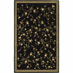 a black rug with flowers and vines on the border, in front of a white background