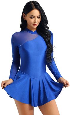 a woman wearing a blue dress with sheer shoulders and long sleeves, posing for the camera