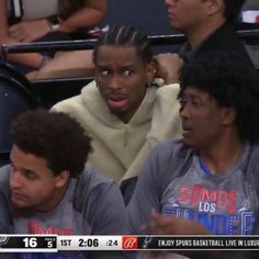 two men sitting next to each other at a basketball game