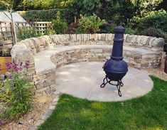 an outdoor fire pit in the middle of a garden