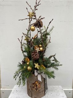 a christmas arrangement with pine cones and ornaments in a rustic tin can on a table