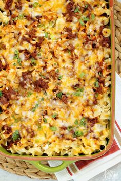 a casserole dish filled with pasta, meat and cheese on a red and white towel