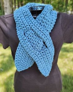 a woman wearing a blue crocheted scarf on top of a brown t - shirt