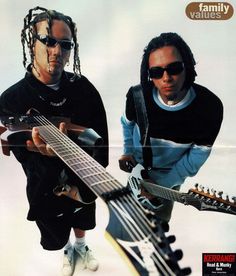 two men with dreadlocks are holding guitars and looking at the camera while standing next to each other