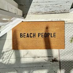 a door mat with the words beach people on it next to a potted plant