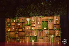 the stage is decorated with wooden crates and greenery