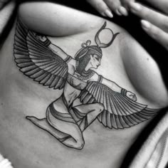 a woman's stomach with an egyptian tattoo design on her belly and the wings