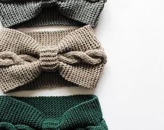 three knitted bow ties laying next to each other on top of a white surface