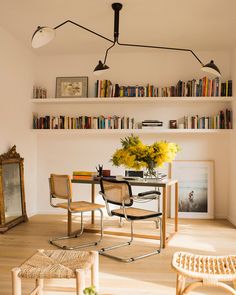 a dining room table and chairs with bookshelves in the background