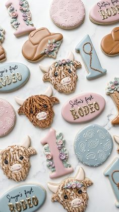 decorated cookies are arranged in the shape of farm animals and numbers on a marble surface