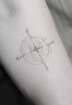 a small compass tattoo on the arm