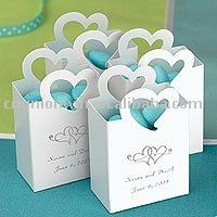 small white boxes with blue hearts are on a table next to a green and white polka dot ribbon