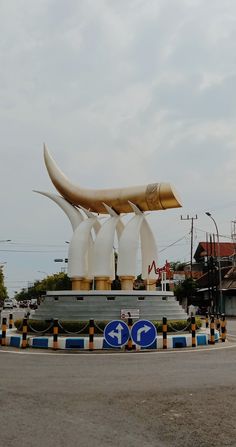 a large white sculpture sitting on the side of a road