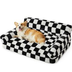 a dog laying on top of a black and white checkerboard pet couch with his tongue out