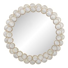 a round mirror with circles on the bottom and gold trimmings, in front of a white background