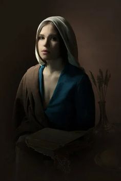 a woman in a blue dress is holding a box with wheat stalks on the table