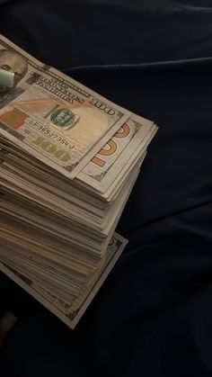 a stack of money sitting on top of a bed