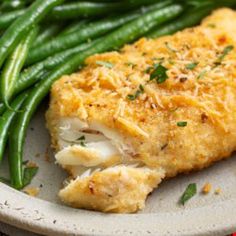 a white plate topped with green beans and chicken