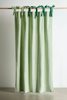 a green curtain hanging on the side of a wall