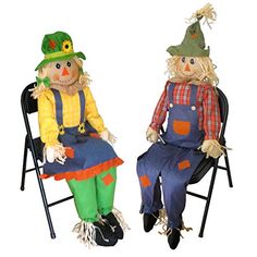 two scarecrows are sitting in lawn chairs