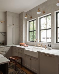 a kitchen with white cabinets and gold faucets on the windowsills is pictured in this image