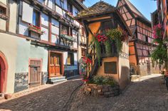 a cobblestone street in an old european town with half - timbered buildings